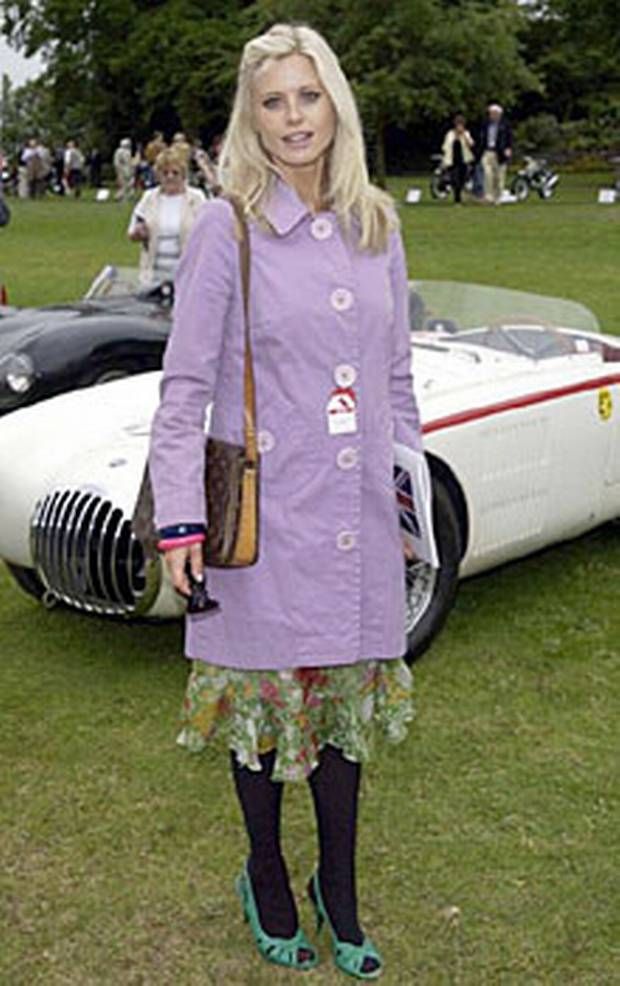 a woman standing in front of a vintage car