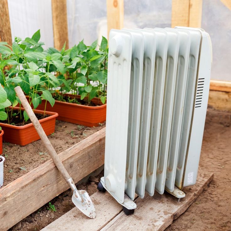 a radiator sitting on top of a wooden pallet next to potted plants