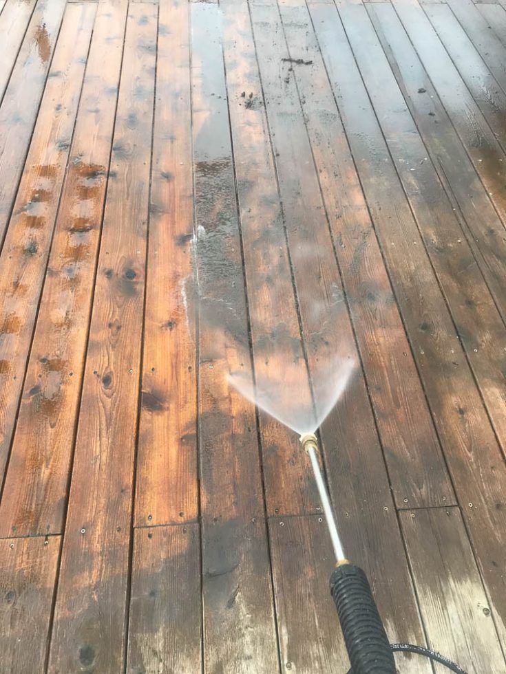 a hose is attached to a wooden deck with water coming out of it and spraying on the wood