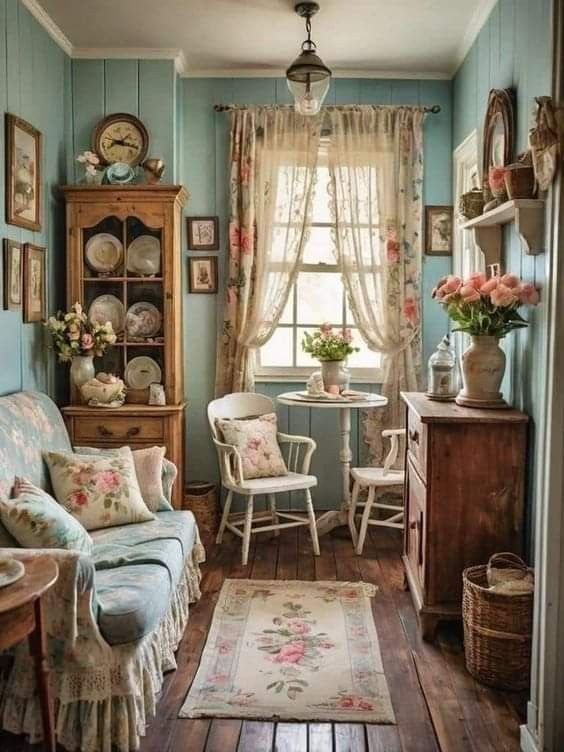 a living room filled with furniture and flowers in vases on the window sill