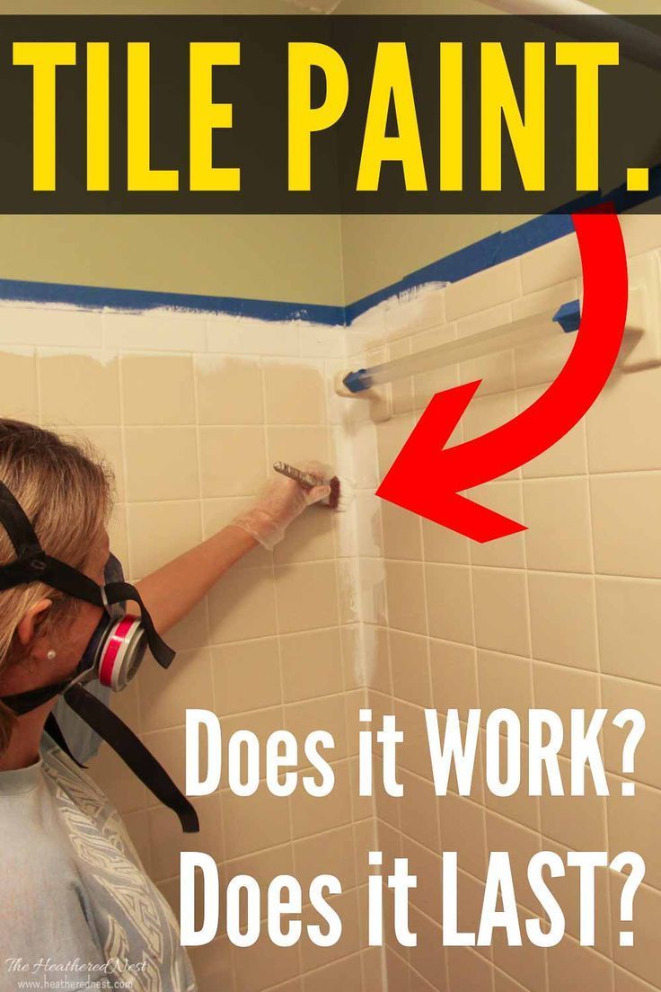 a woman is painting the wall in her bathroom with white tile and red arrow pointing to it