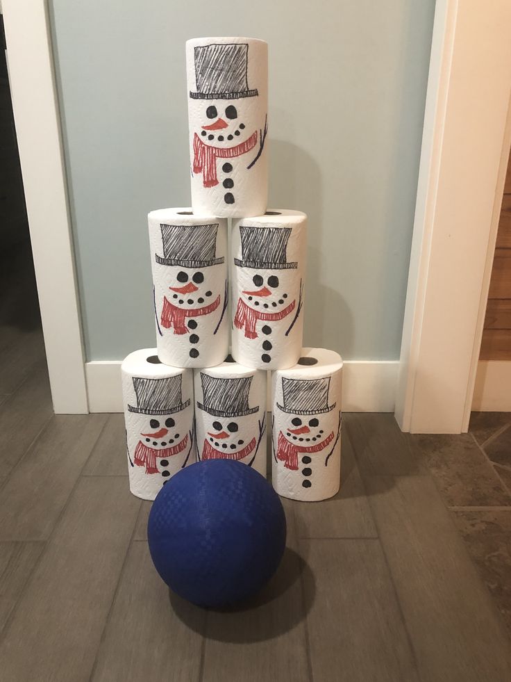 a pile of toilet paper sitting on top of a wooden floor next to a blue ball