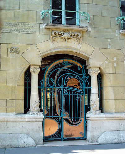 an old building with a blue iron door and ornate design on the front entrance to it