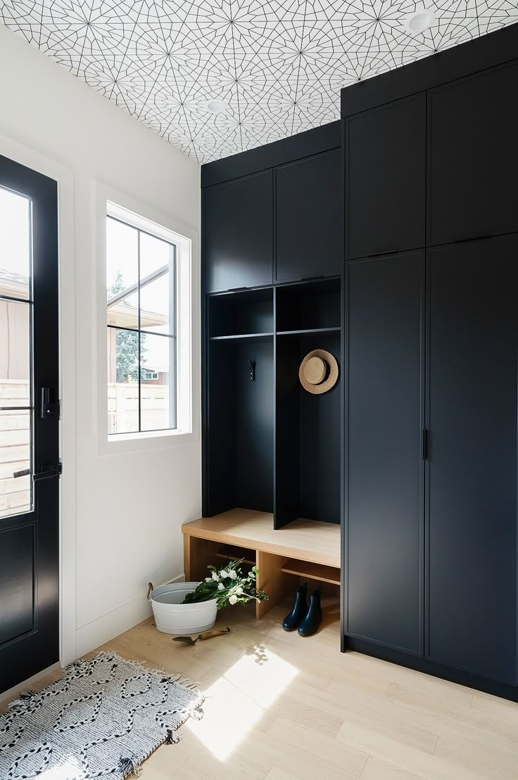 a room with black cupboards and a white bowl on the floor next to it