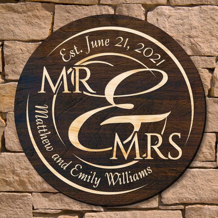 a wooden sign with the words mr and mrs on it next to a brick wall