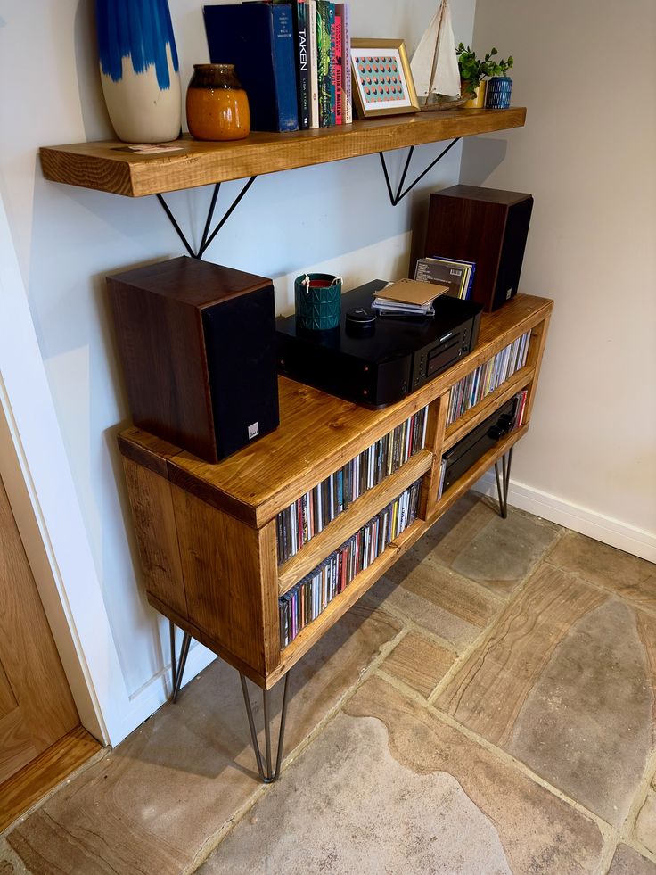 an entertainment center with bookshelves, speakers and other items on top of it