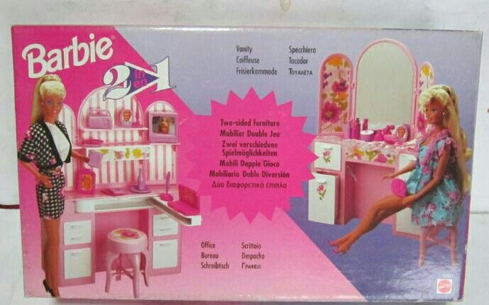 a barbie doll plays in her pink dressing table and chair set with accessories on it