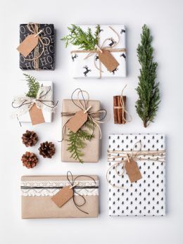 presents wrapped in brown and white paper tied with twine, pine cones, fir branches, and tags