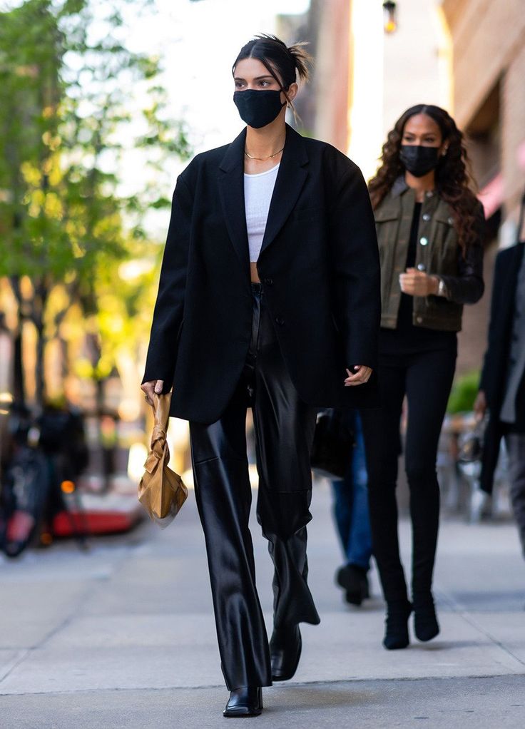 a woman wearing a face mask walking down the street