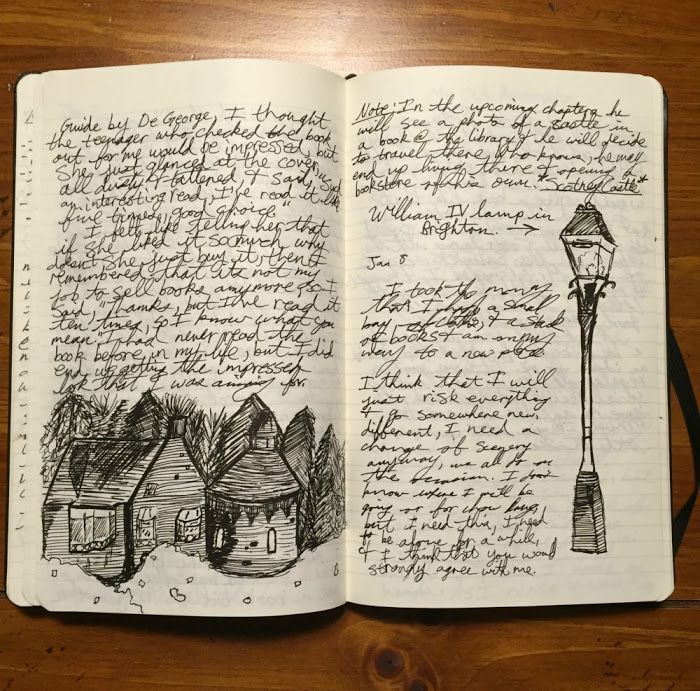 an open notebook with writing on it and a lamp post in the middle, sitting on top of a wooden table