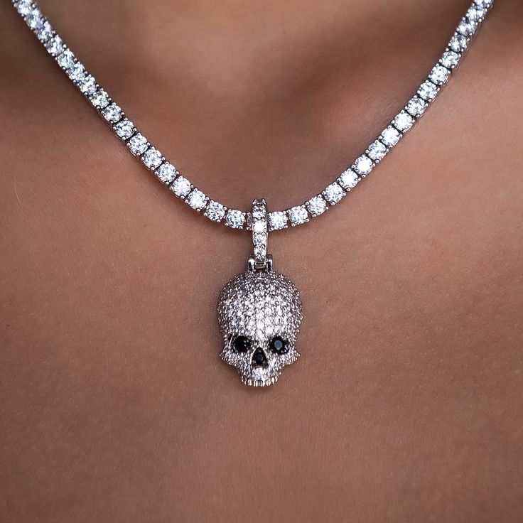 Introducing the Iced Black Stone Skull Pendant, intricately designed and crafted to perfection. This eye catching piece features a fully iced out skull head decorated with black hand-set stones. Micro-sized yet bold, wear this pendant on our 3mm Diamond Tennis Necklace for an edgy look that is sure to shine! This product is guaranteed for life - GLD will repair the item should you experience any defects in craftsmanship or breakage. Specifications - 14mm x 22mm (Width x Height) - Weight: (Weight Skull Print Metal Jewelry For Streetwear, Black Skull Print Jewelry For Streetwear, Halloween Skull Print Jewelry For Streetwear, Halloween Skull Print Jewelry, Silver Jewelry With Skull Print For Streetwear, Silver Skull Print Jewelry For Streetwear, Skull Print Gothic Jewelry For Streetwear, Diamond Skull, Diamond Tennis Necklace