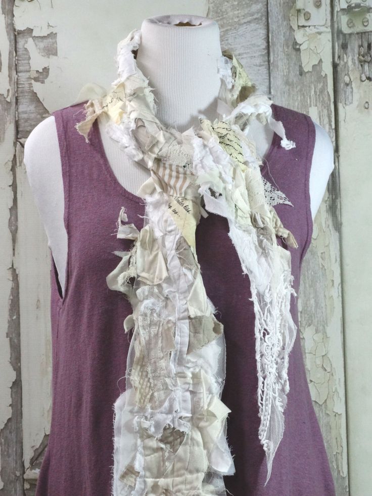 a white mannequin wearing a purple shirt and scarf