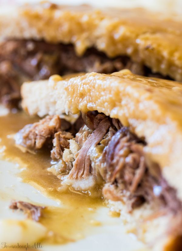 a close up view of some food on a white plate with brown gravy