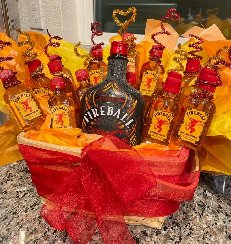 a bottle of fireball whiskey in a gift basket with red ribbon and yellow wrapping