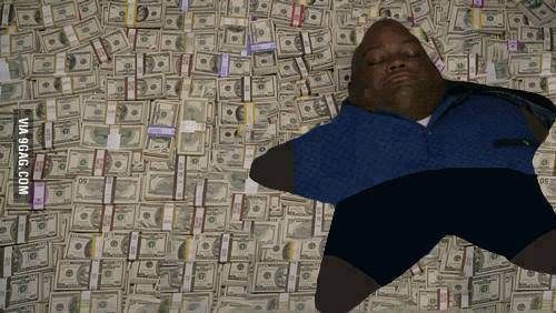 a man laying on top of a bed covered in lots of dollar bill bills and wearing a blue shirt