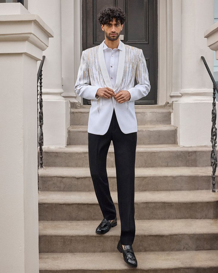 This tuxedo set features intricate silver and gold embroidery in a linear waterfall pattern. The ivory jacket has a single - buttoned shawl satin lapel. The crisp white pin tucked shirt shows black porcelian buttons. It comes with contrasting black straight pants.From Seema Gujral's For the love of London collection. DELIVERY TIMEPlease allow 8-12 weeks for your outfit to arrive. FABRIC DETAILSNet Professional cleaning only. Black Straight Pants, Ivory Tuxedo, Wedding Clothes For Men, Indian Wedding Clothes For Men, Indian Wedding Clothes, White Tuxedo, White Pin, Wedding Clothes, Arabian Nights