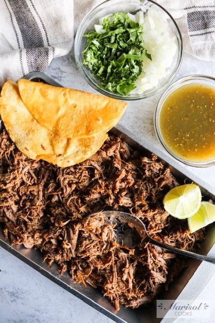 shredded beef with salsa and tortilla chips on a serving tray next to dipping sauce