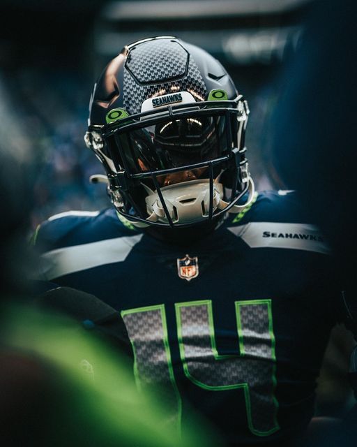 a football player wearing a black and green uniform