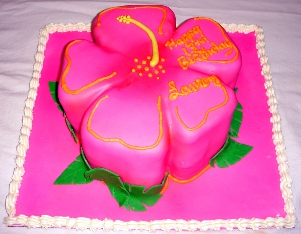 a pink cake decorated with flowers and hearts