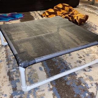 a dog bed on top of a rug in a living room