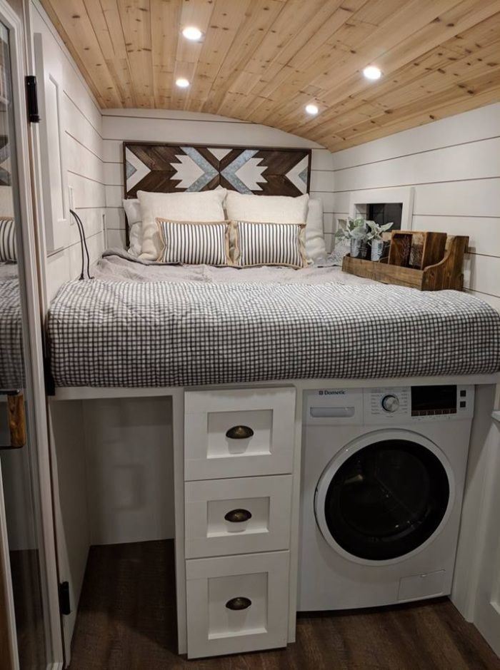 a small bedroom with a bed, washer and dryer