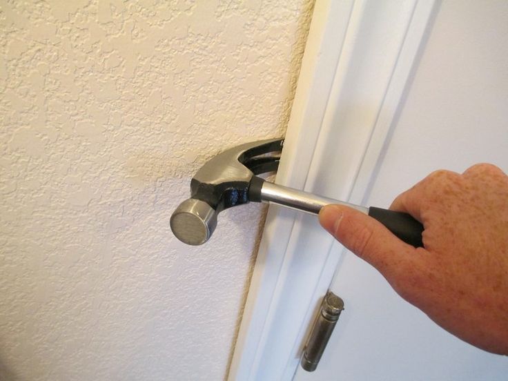 a hand holding a wrench to open a door