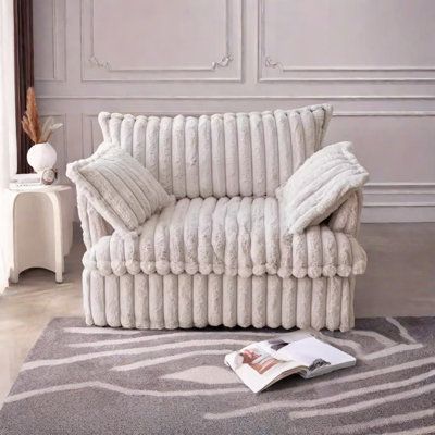 a white couch sitting on top of a gray rug