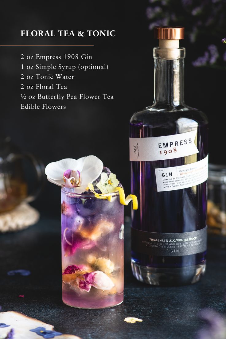 a bottle of tea next to a tall glass filled with flowers and ice cubes