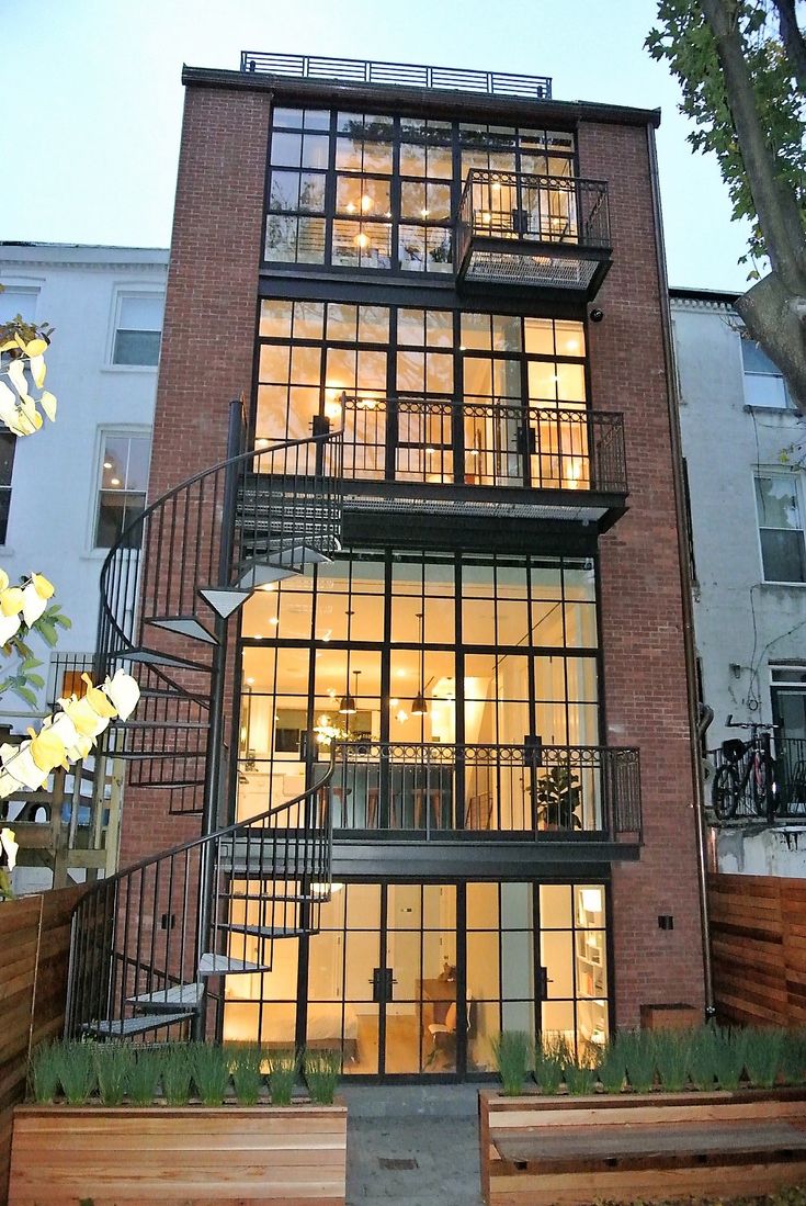 an apartment building with stairs leading up to the second floor and windows on each side