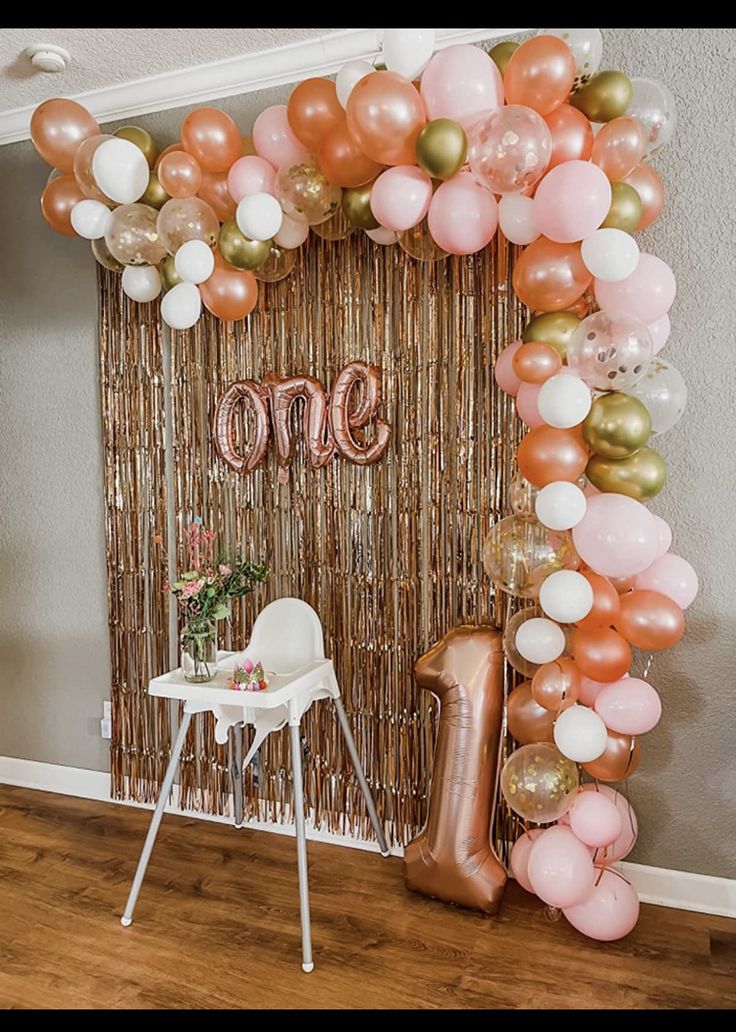 a balloon arch with balloons and one on the wall for a first birthday party or baby shower