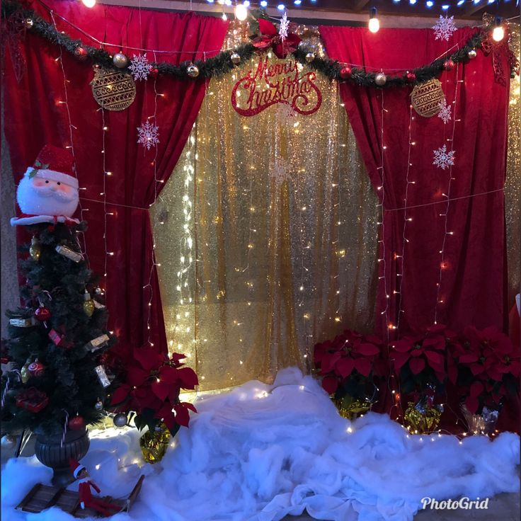 a red and gold christmas display with lights on it's sides, snowflakes hanging from the ceiling