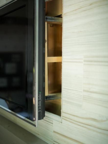 a microwave oven sitting inside of a kitchen next to a wall mounted cabinet with wooden shelves