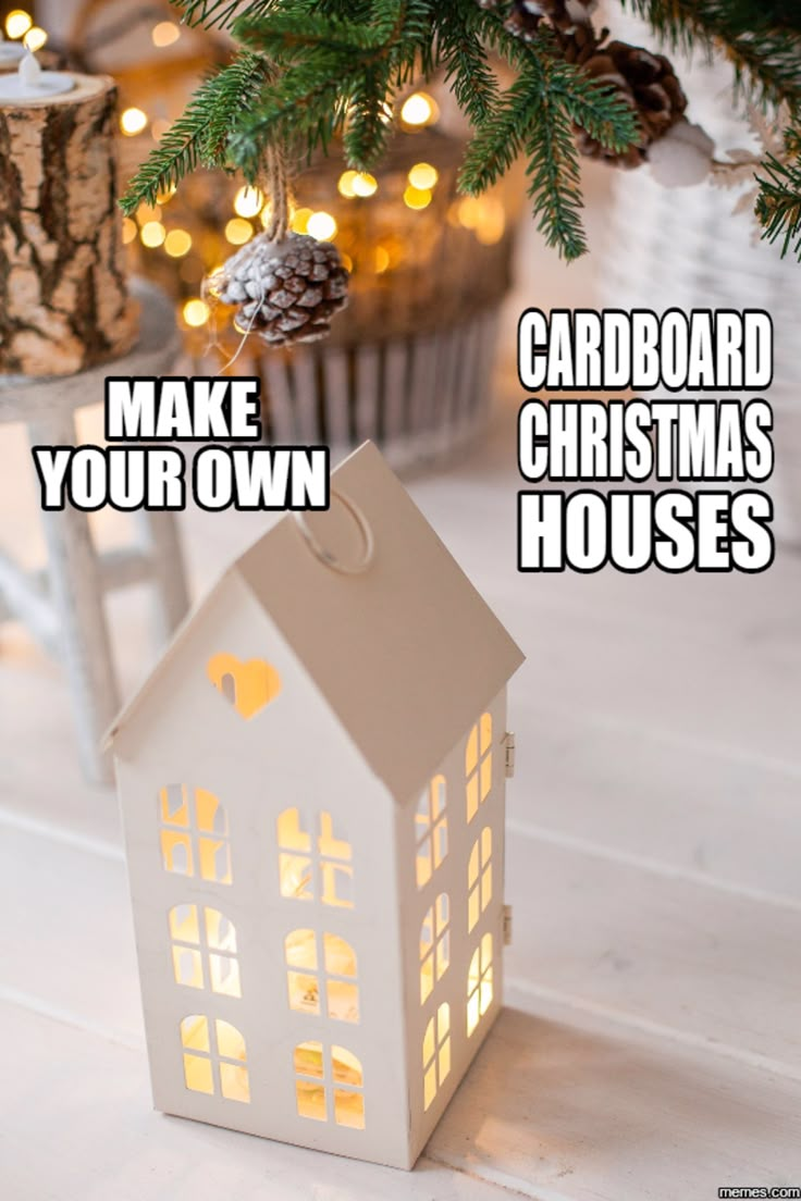 a small white house sitting on top of a wooden table next to a christmas tree