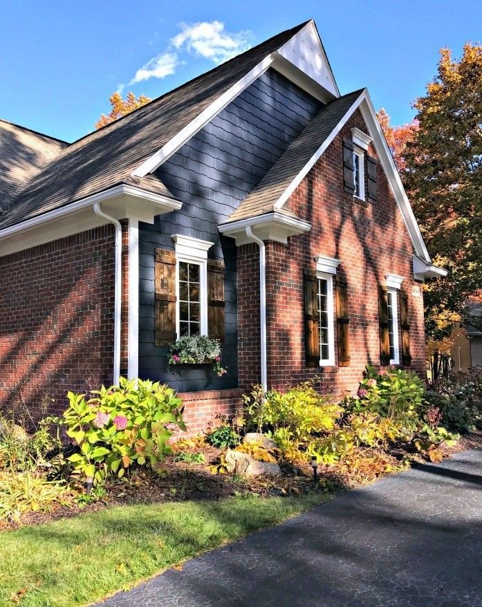 a brick house with black shutters and white trim