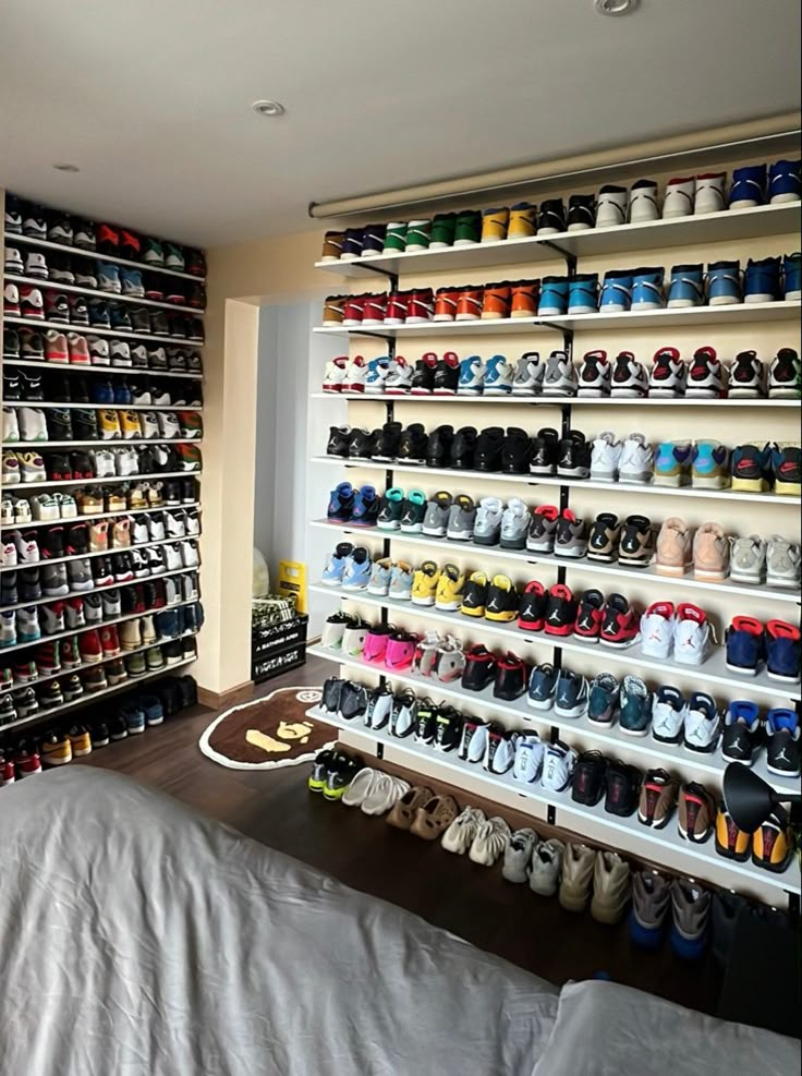 a room filled with lots of shoes next to a bed