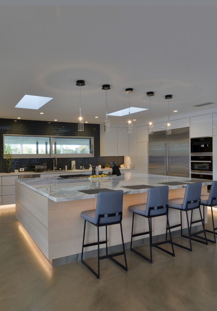 a large kitchen with an island and bar stools