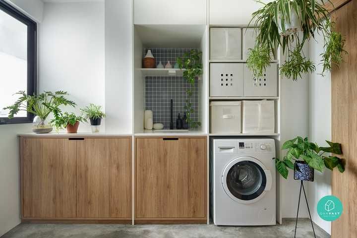 a washer and dryer in a small room with plants on the shelf next to it