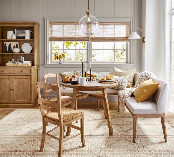 a dining room table and chairs in front of a window