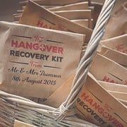 a basket full of hangover kits sitting on top of a wooden table next to a sign that reads hangover kit