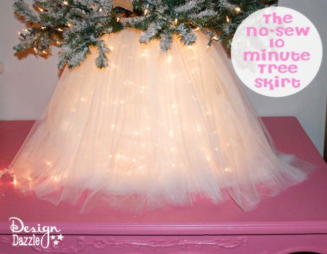 there is a pink table with a white dress and christmas tree on it, which has lights all over the top