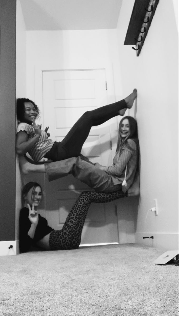 three women hanging out in the corner of a room with their feet up and legs down