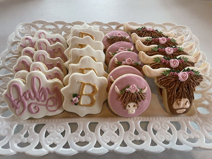 decorated cookies are arranged on a platter with the letters b and d spelled out