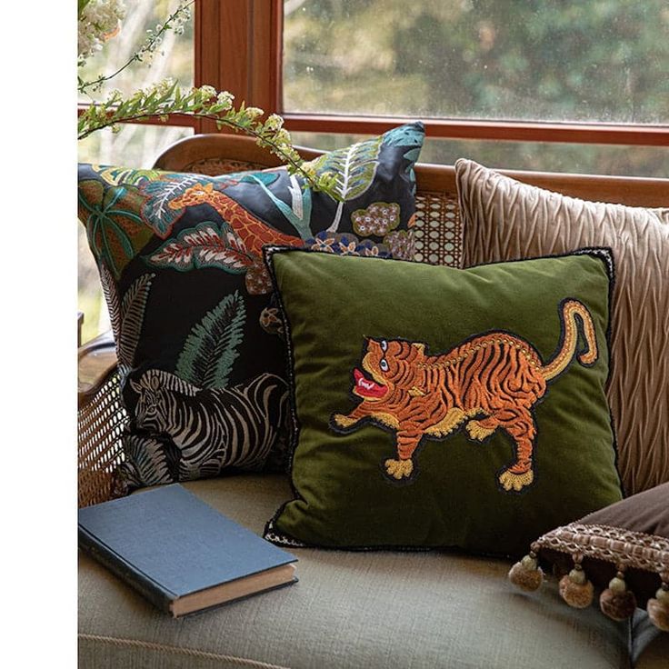 the pillows on the couch are decorated with an image of a tiger and other animals