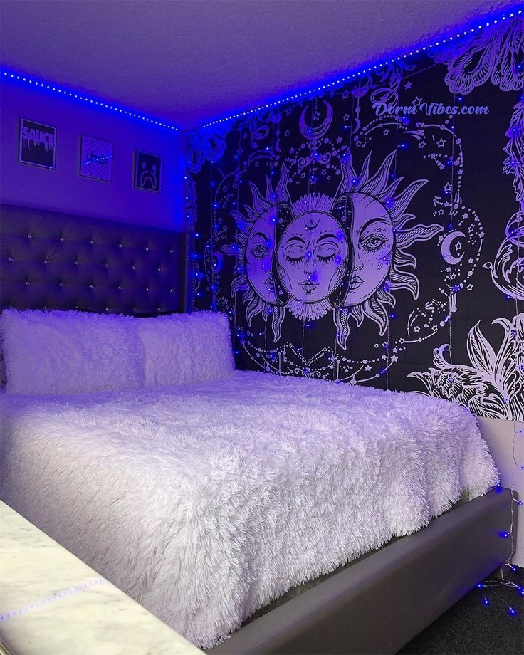 a white bed sitting under a purple light in a bedroom