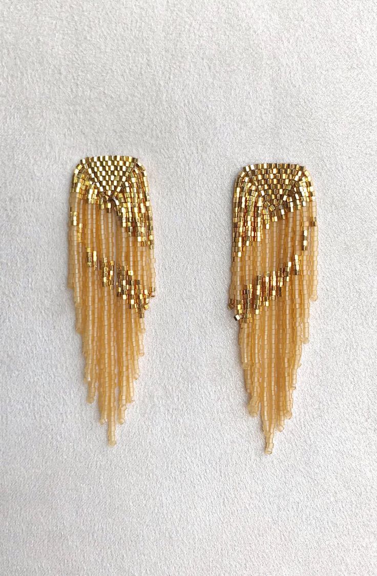 pair of gold beaded wings on white background