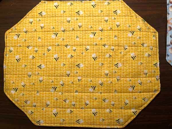 a close up of a yellow piece of cloth on a wooden table with other items