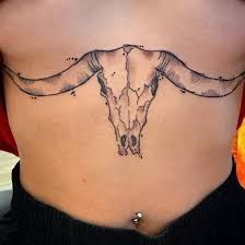 a cow skull tattoo on the back of a woman's lower body is shown