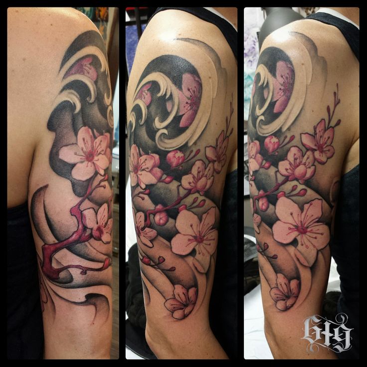 a woman's half sleeve with flowers and swirls on her arm, in black and grey