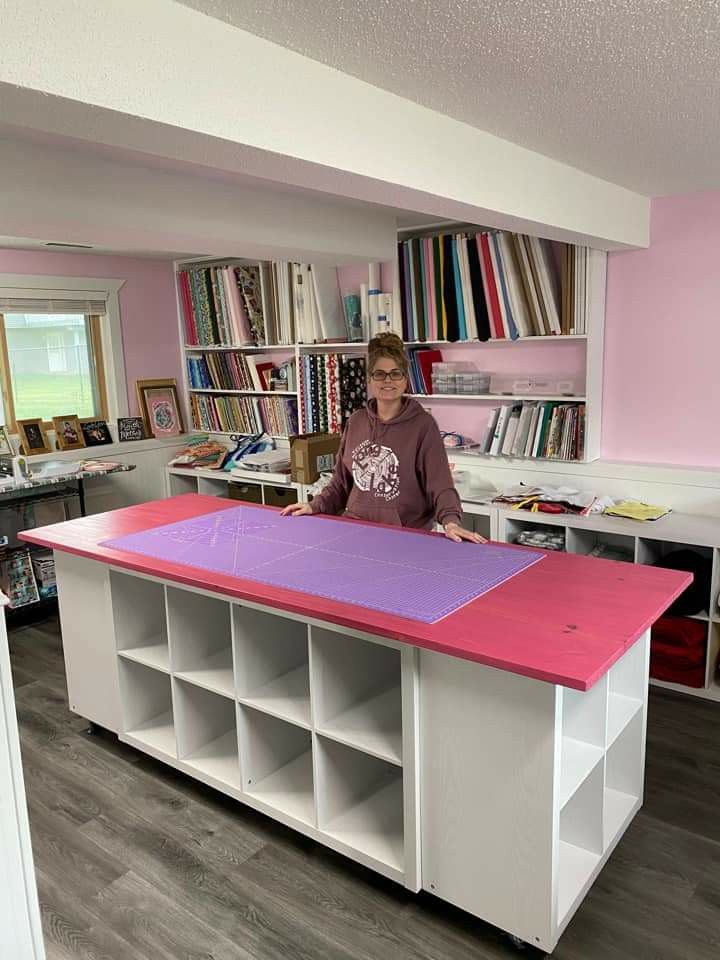 a woman standing in front of a pink and white counter