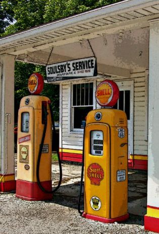 an old gas station with two yellow and red gas pumps next to eachother